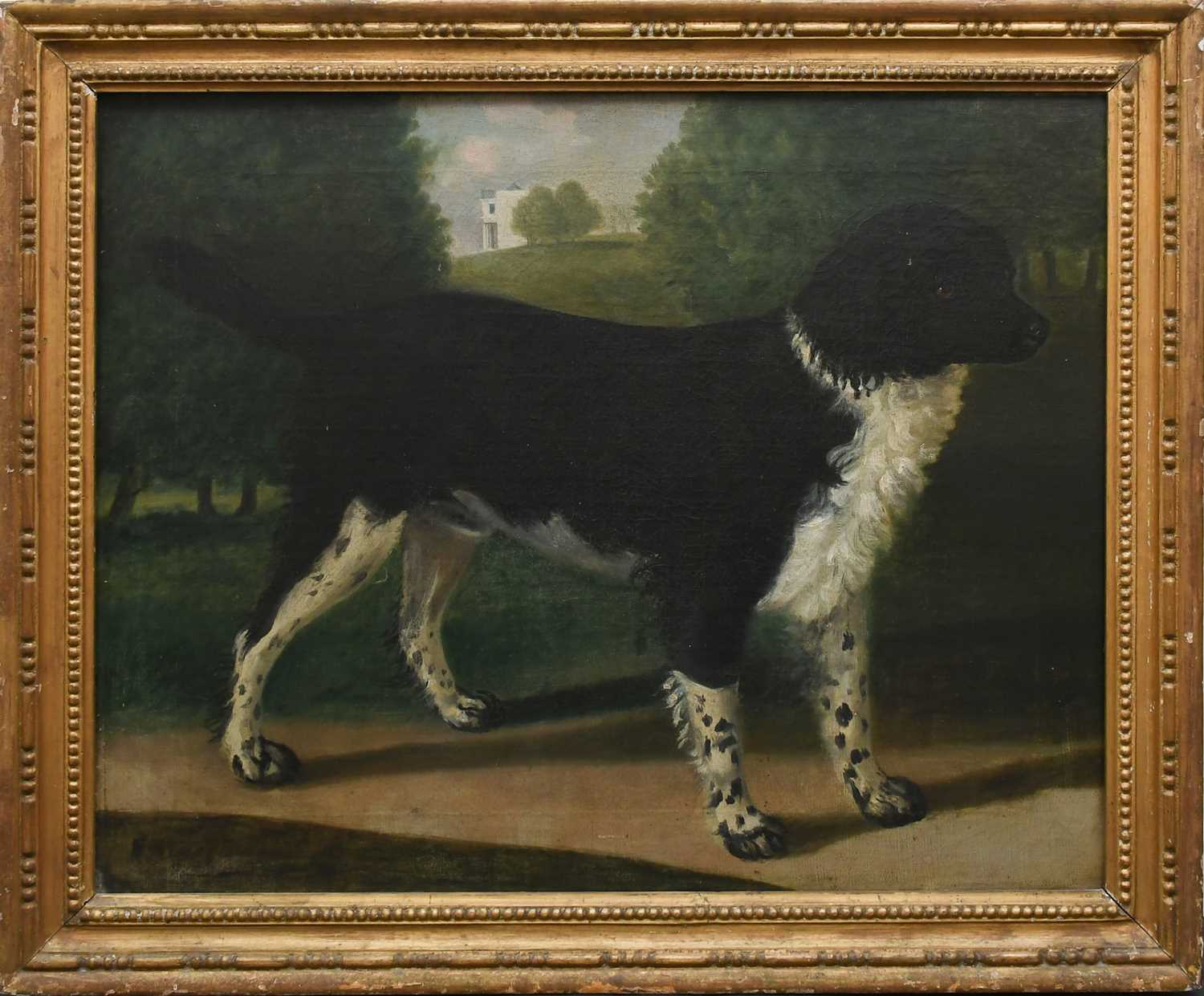 ENGLISH SCHOOL EARLY 19TH CENTURY Portrait of a spaniel standing in a park with a country house