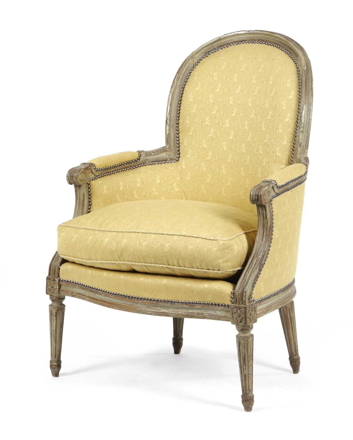 A FRENCH PAINTED BERGÈRE IN LOUIS XVI STYLE, 19TH CENTURY with an arched back and a moulded frame
