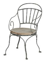 A VICTORIAN PAINTED WROUGHT IRON GARDEN ARMCHAIR 19TH CENTURY with scroll arms and a solid wood seat