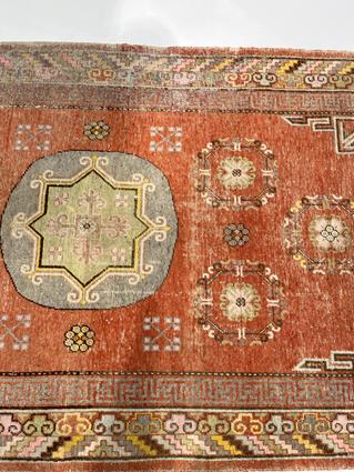 A KHOTAN RUG EAST TURKESTAN, C.1920 the pale terracotta field centred by a rondel framed by six - Image 3 of 5
