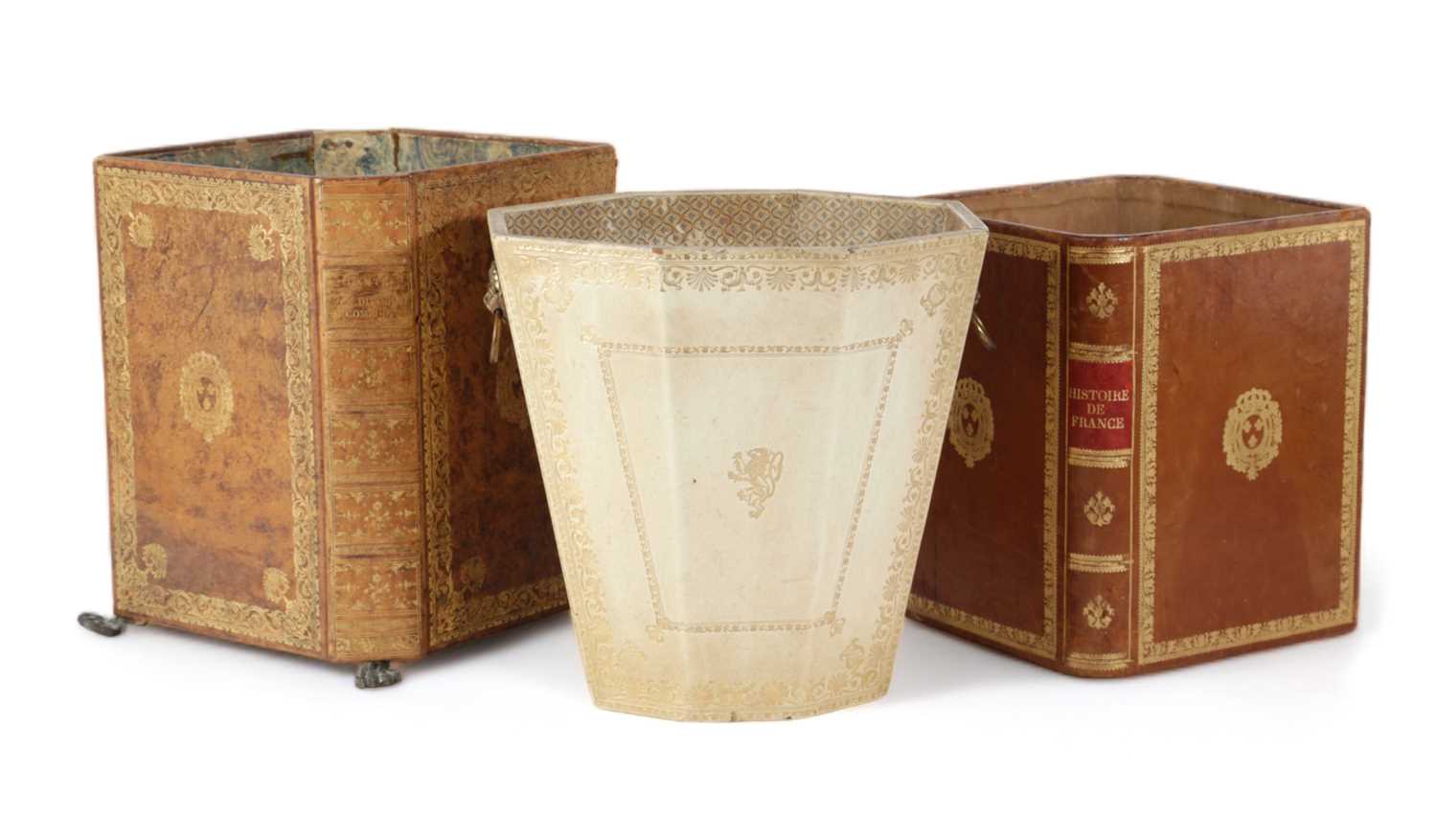 THREE LEATHER WASTE PAPER BASKETS 20TH CENTURY two with faux book bindings, one on brass paw feet