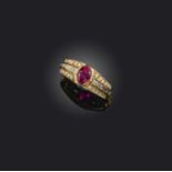 A ruby and diamond ring, set with an oval ruby within diamond-set shoulders in yellow gold, size M