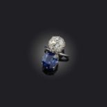 An impressive sapphire and diamond ring, of toi et moi design, set with a cushion-shaped diamond and