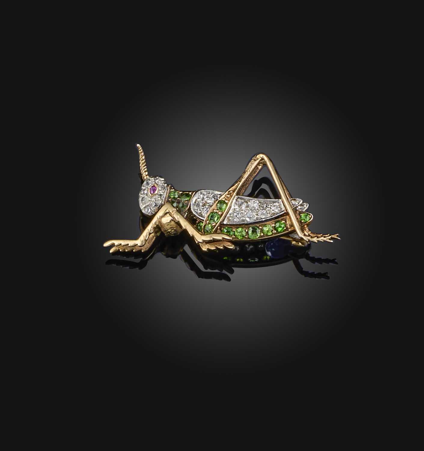 A demantoid garnet, ruby and diamond brooch, early 20th century, designed as a grasshopper, set with