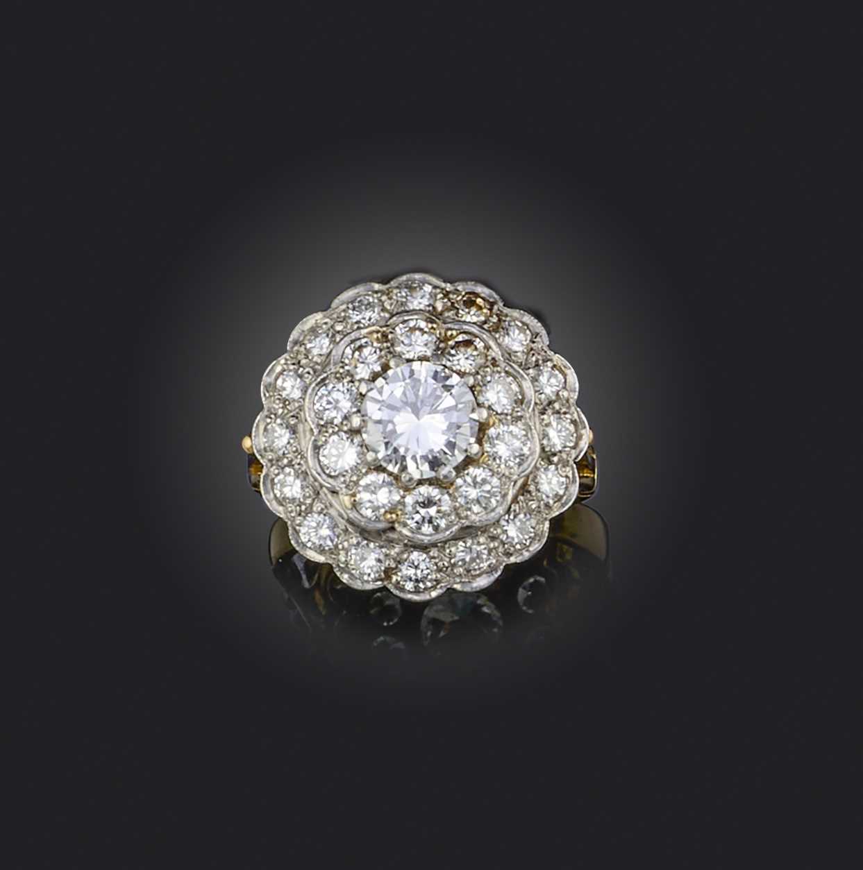 A diamond cluster ring, set with a central round brilliant-cut diamond weighing approximately 1.