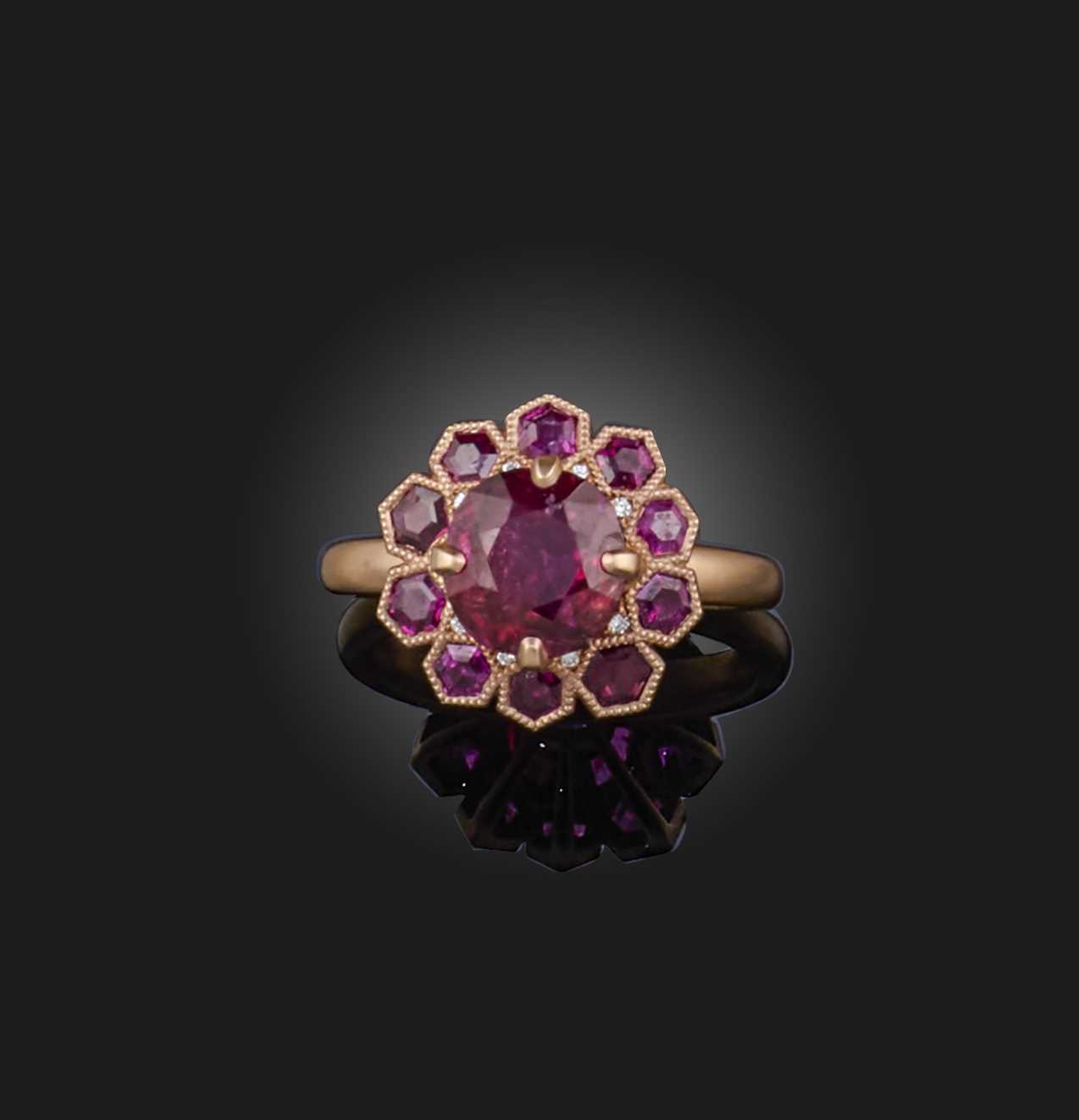 A ruby ring, of cluster design, centring on a cushion-shaped ruby weighing approximately 3.80