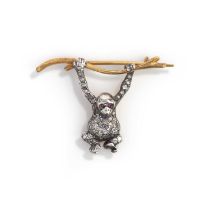 A diamond brooch, designed as a monkey hanging from a tree branch, set with brilliant- and single-