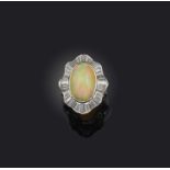 An opal and diamond ring, collet-set with a cabochon opal weighing 5.37 carats, within an undulating