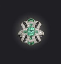 An emerald, onyx and diamond ring, designed in the Art Deco style, centring on a with a step-cut