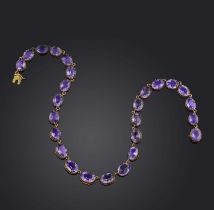 An amethyst rivière necklace, 19th century, composed of graduated oval amethysts in gold collet