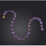 An amethyst rivière necklace, 19th century, composed of graduated oval amethysts in gold collet