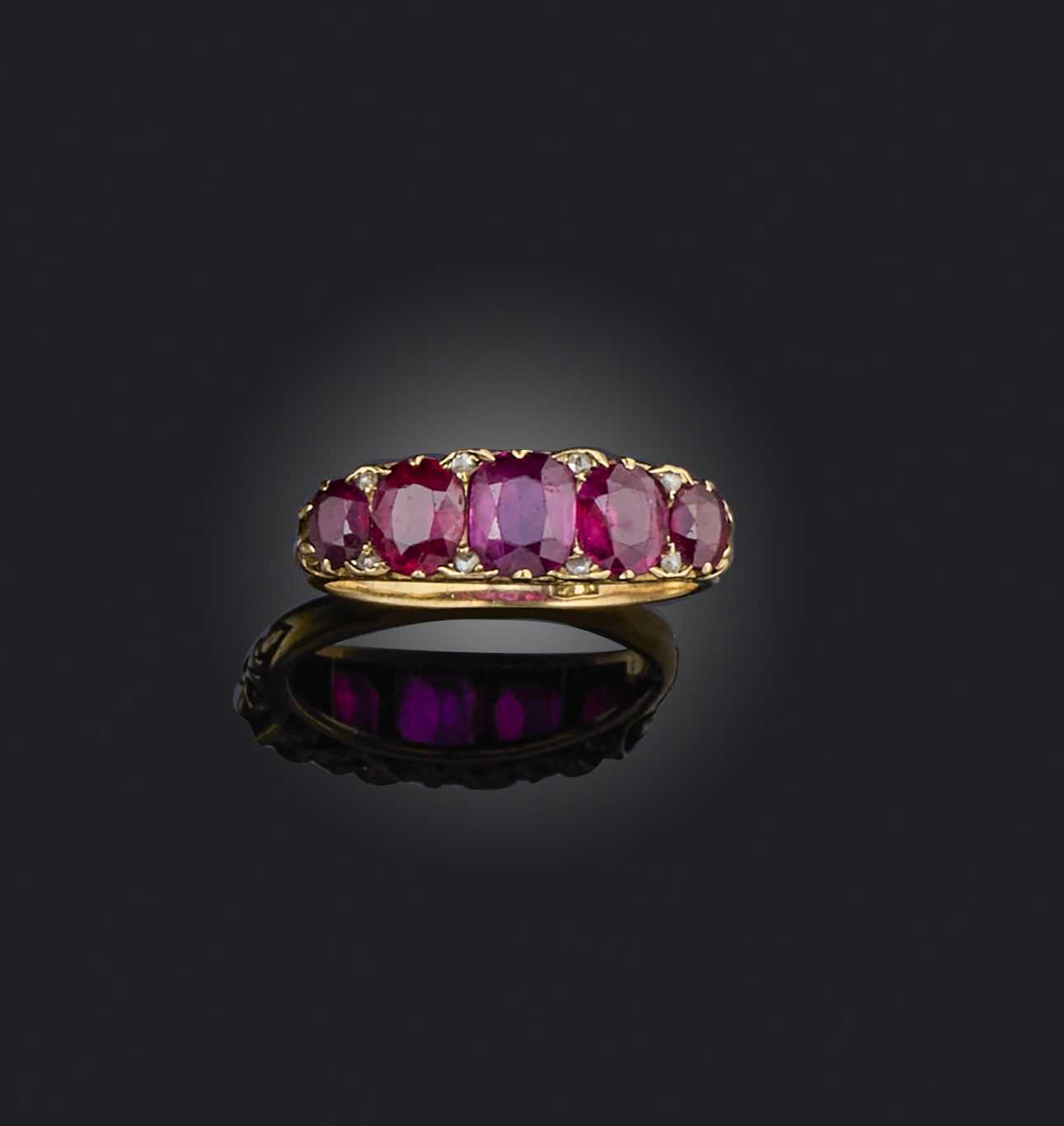 A ruby five-stone ring, set with graduated cushion-shaped rubies spaced with diamonds, in a carved