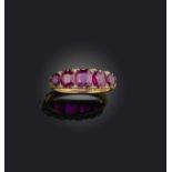 A ruby five-stone ring, set with graduated cushion-shaped rubies spaced with diamonds, in a carved