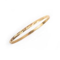 No reserve - a gold bangle, the solid band with engraved decoration, in high-carat gold, inner