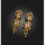 A pair of topaz and gold drop earrings, of stylised design set with graduated oval-shaped topaz