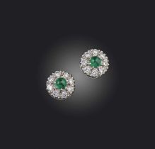 A pair of emerald and diamond stud earrings, each of cluster design, set with a cabochon emerald