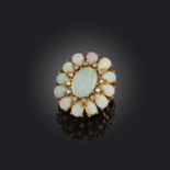 An opal and diamond cluster ring, set with a central solid white opal within a diamond and opal
