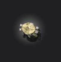 A yellow sapphire and diamond ring, the oval yellow sapphire flanked with pairs of circular-cut