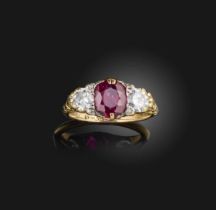 A ruby and diamond three-stone ring, centring on a cushion-shaped ruby weighing approximately 1.70