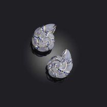 A pair of earrings designed as spiral seashells, set with polished white chalcedony and circular-cut