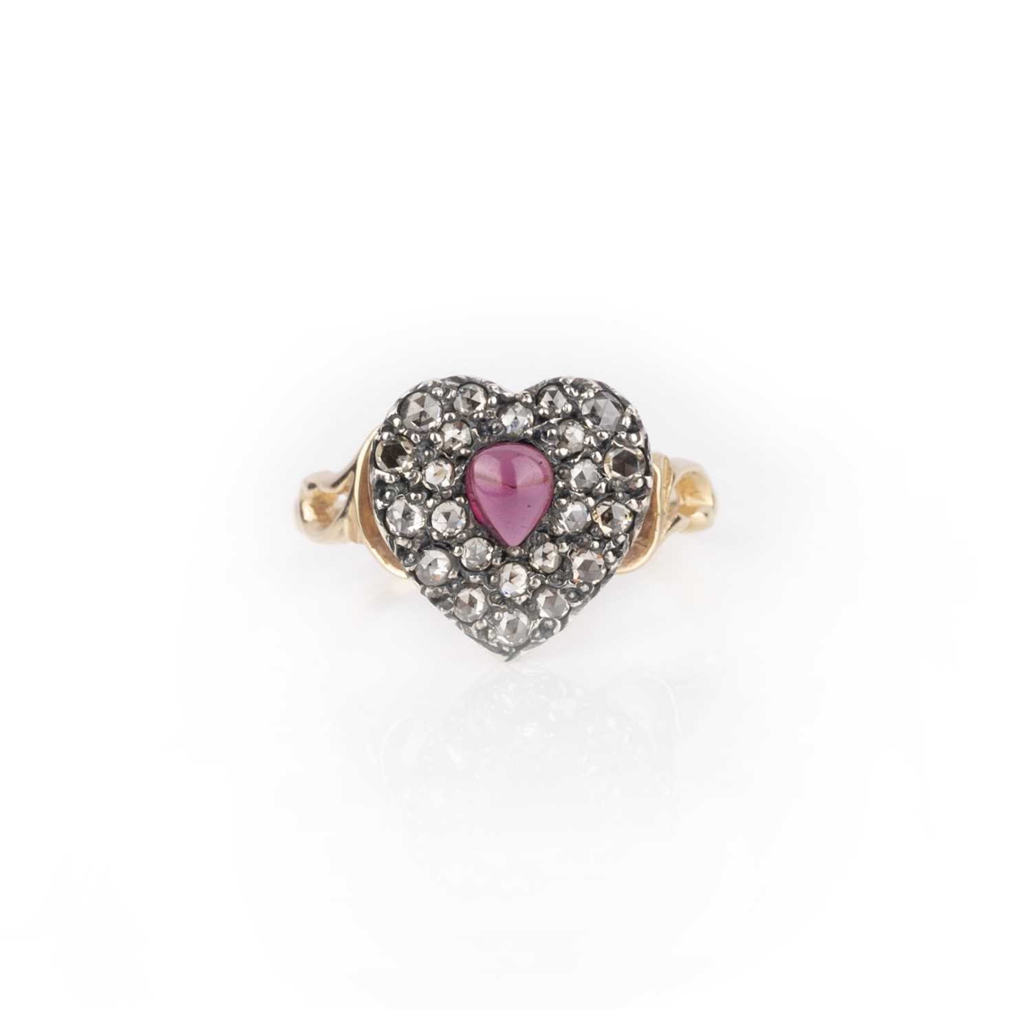 A garnet and diamond ring, centring on a heart-shaped motif set with a cabochon garnet and rose-