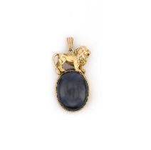 A sapphire pendant, set with a large cabochon sapphire, within a gold mount topped with a lion,