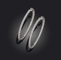 A pair of diamond earrings, each of hoop design, set with brilliant-cut diamonds, mounted in white