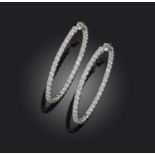 A pair of diamond earrings, each of hoop design, set with brilliant-cut diamonds, mounted in white