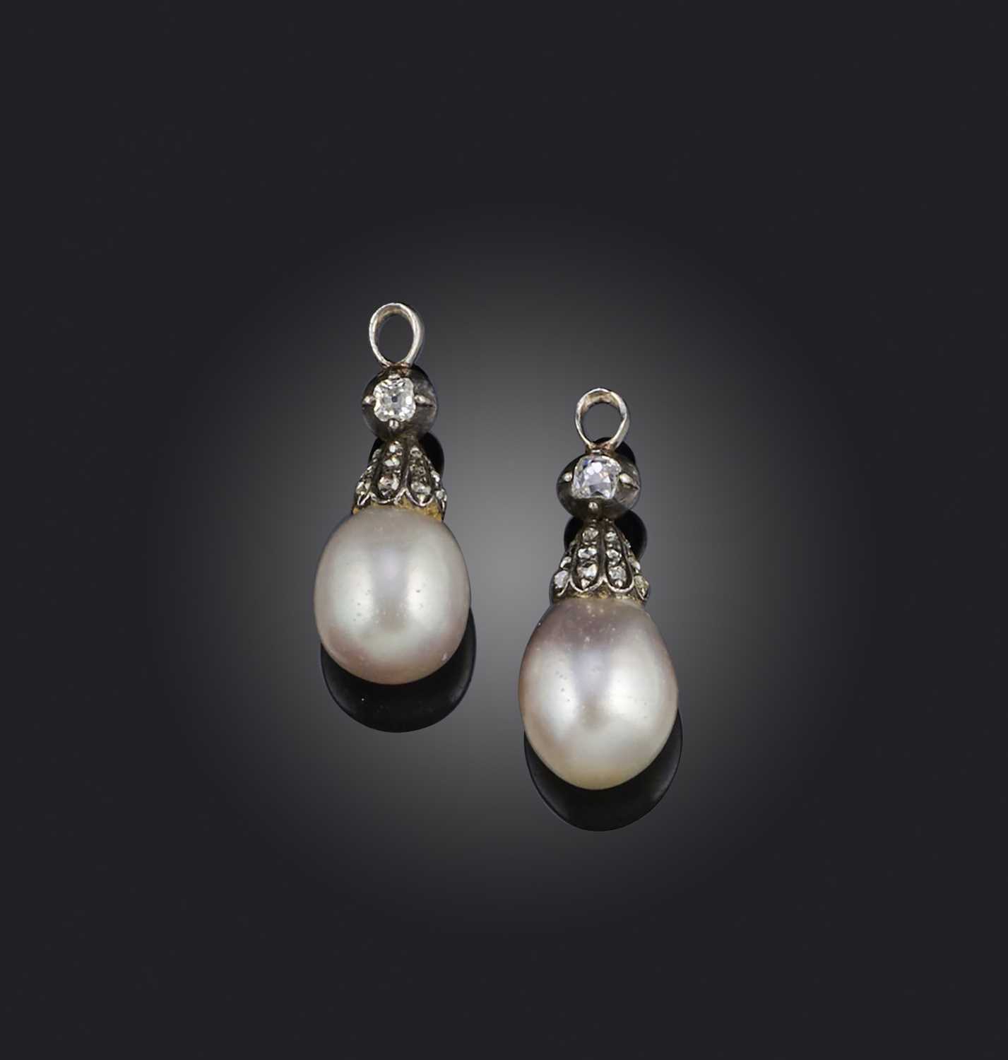 A pair of natural pearl drops, each set with a cushion-shaped diamond above a diamond-set cap