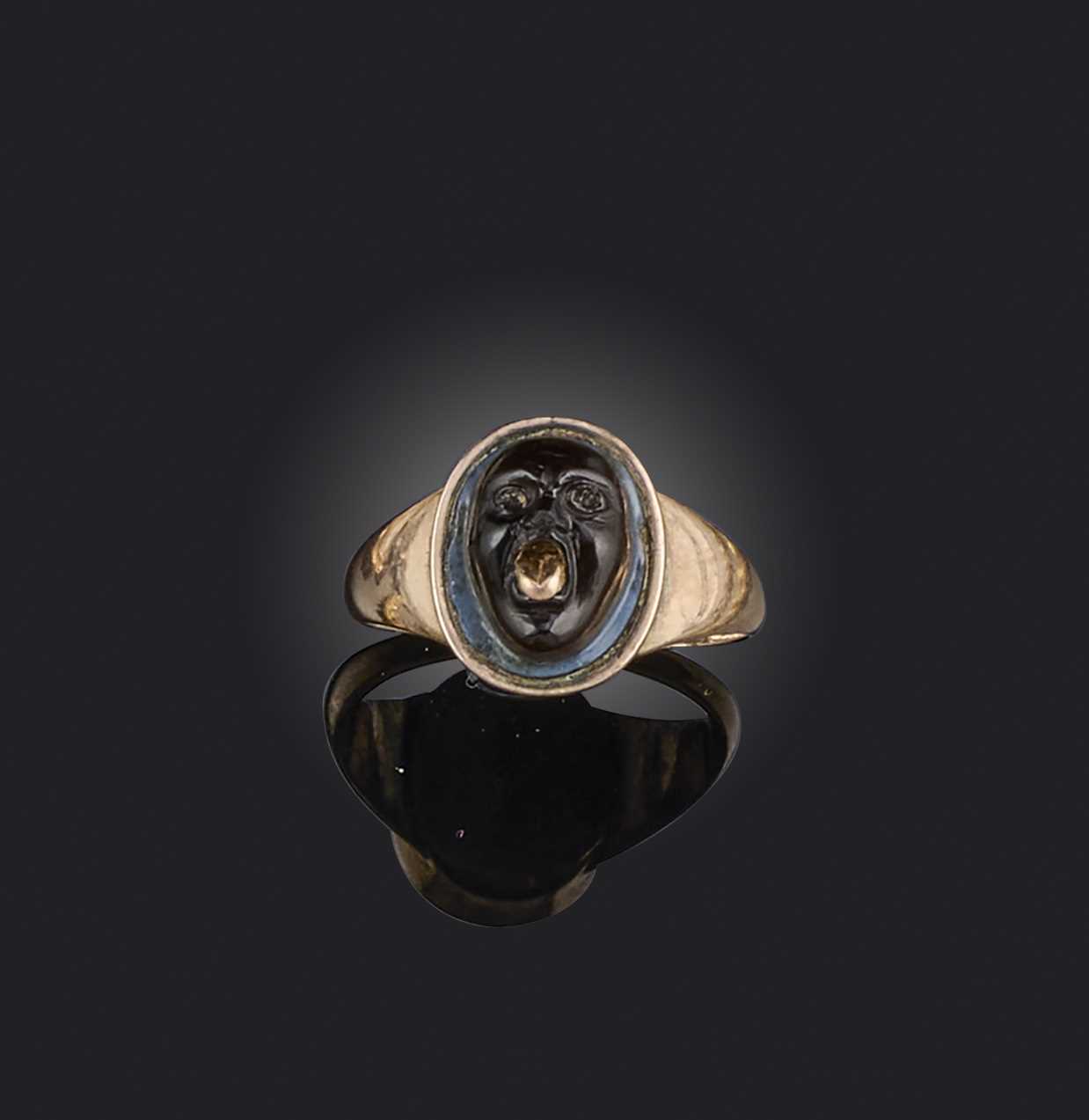An early 19th century cameo ring, set with a banded agate cameo of a grotesque mask with a gold