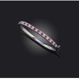 A ruby and diamond bangle, of hinged design, the front channel-set with a sequence of square