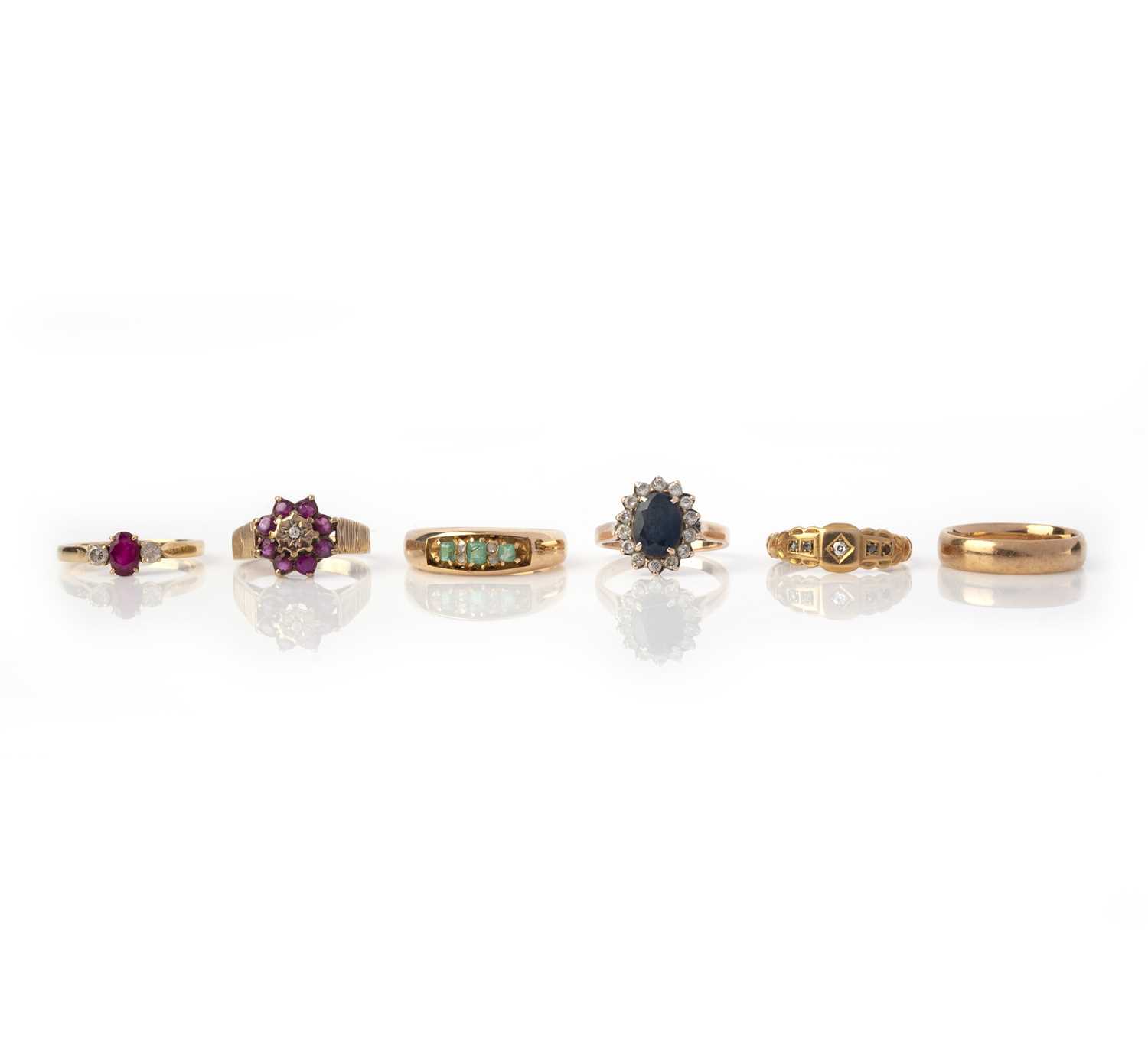 Six gold and gem-set rings, comprising: a 15ct gold ring set with step-cut emeralds and rose-cut