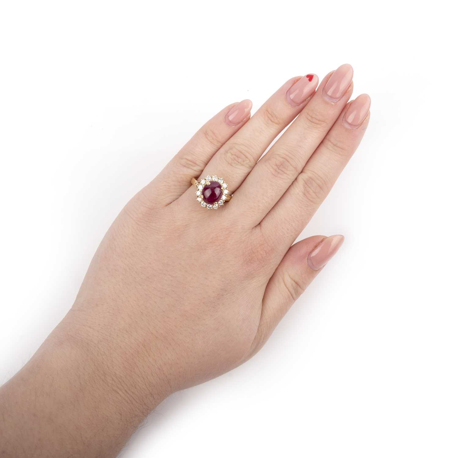 A ruby and diamond ring, of cluster design, set with a cabochon ruby within a border of brilliant- - Image 2 of 2