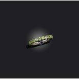 A demantoid garnet eternity ring, set with a continuous line of circular-cut demantoid garnets,