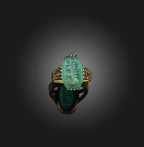 A carved emerald ring, set with an elongated octagonal emerald measuring 15.1 x 9.4 x 4.0mm, its