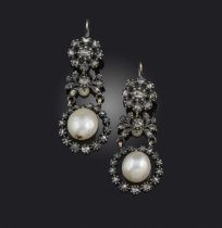 A pair of natural pearl and diamond earrings, each of pendent design, suspending a natural pearl