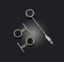 Cartier, a pair of cufflinks and a stickpin (adapted), each disc set with onyx within a border of