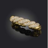 A gold and diamond bangle, of twisted design, pave-set with graduated round brilliant-cut diamonds