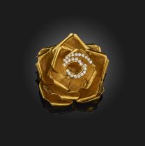 A gold and diamond brooch, designed as a rose in gold, the centre petals outlined with brilliant-cut
