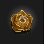 A gold and diamond brooch, designed as a rose in gold, the centre petals outlined with brilliant-cut