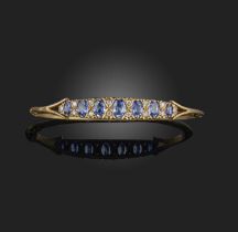 A sapphire and diamond bangle, of hinged design, set to the front with seven graduated oval