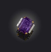 An amethyst and diamond cocktail ring, set with a large mixed cut amethyst, to shoulders channel-set