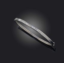 A white gold and diamond bangle, the hinged bangle in 9ct white gold, set to the front with a line
