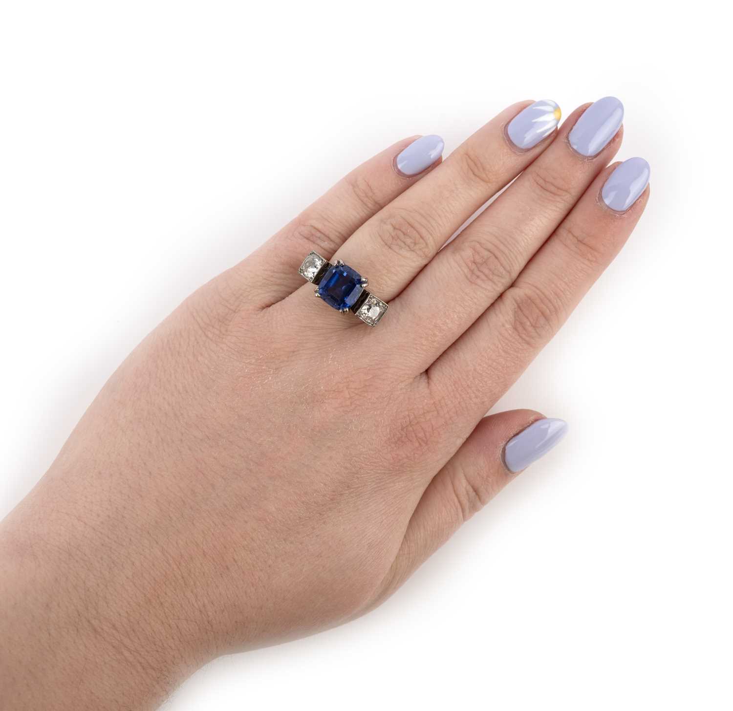 A tanzanite and diamond three stone ring, set with a cushion-shaped tanzanite flanked with old - Image 2 of 2