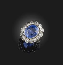 A sapphire and diamond ring, collet-set with a cushion-shaped sapphire weighing approximately 5.50