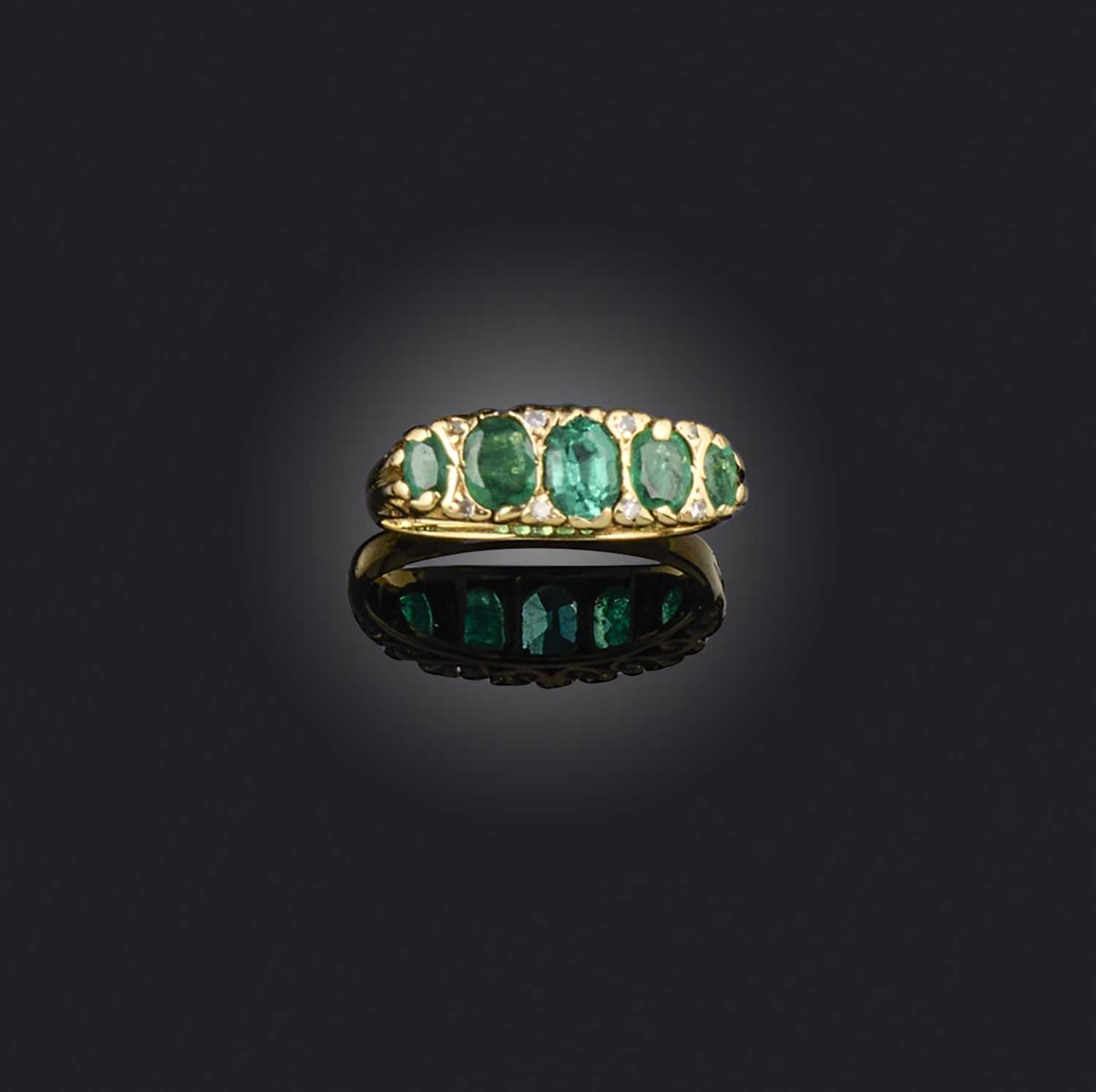 An emerald and diamond ring, set with oval emeralds, spaced by small single-cut diamonds, to a