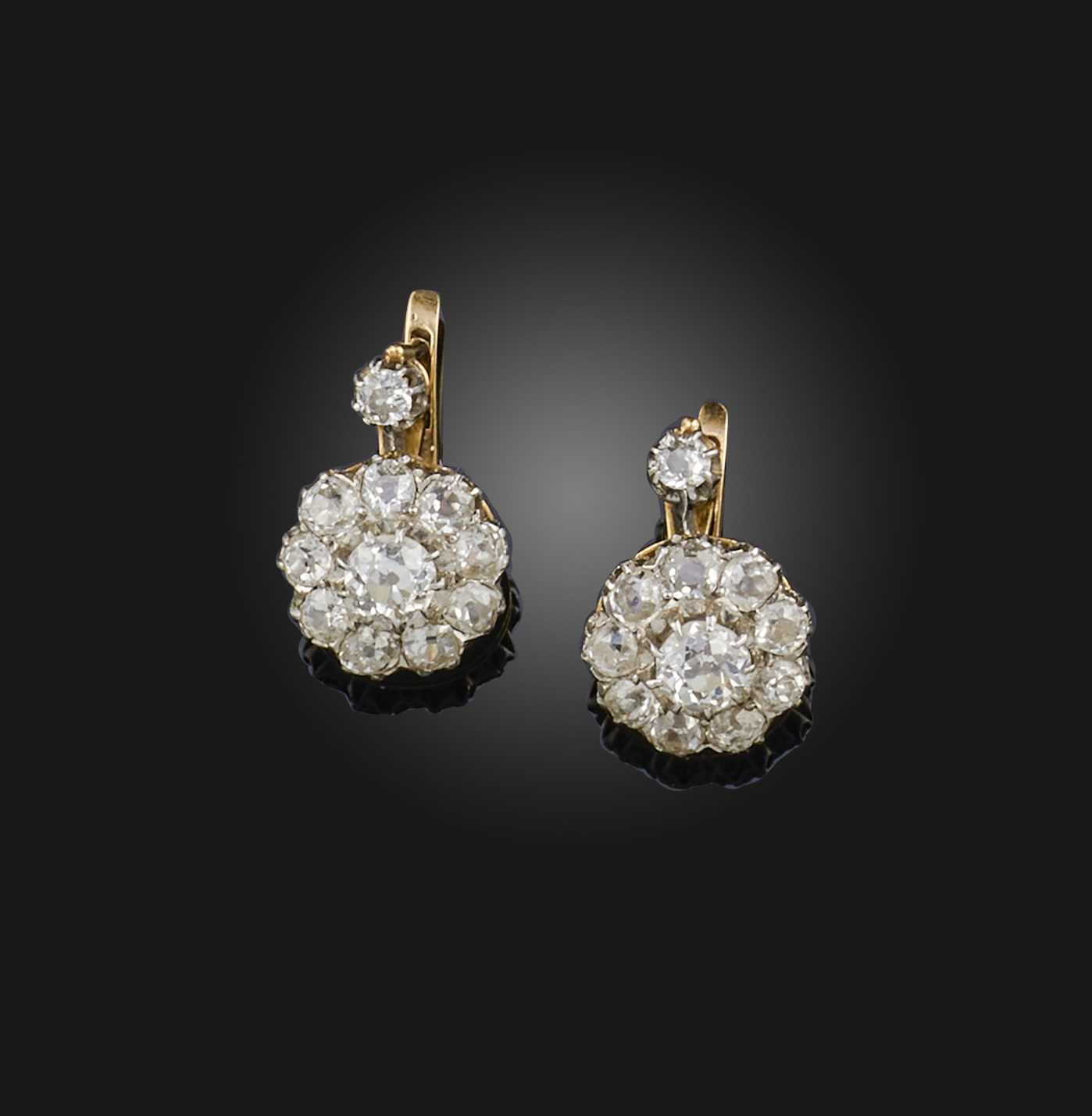 A pair of diamond earrings, circa 1900, each suspending a cluster of cushion-shaped diamonds,