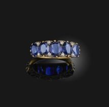 A sapphire and diamond ring, early 20th century, set with a series of five graduated oval sapphires,