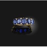 A sapphire and diamond ring, early 20th century, set with a series of five graduated oval sapphires,