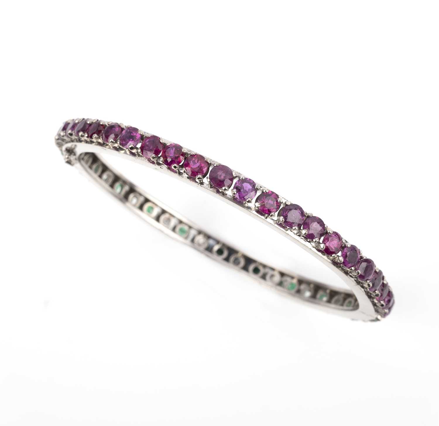 An emerald, ruby and diamond bangle, of hinged design, set to one side with circular-cut emeralds - Image 2 of 2